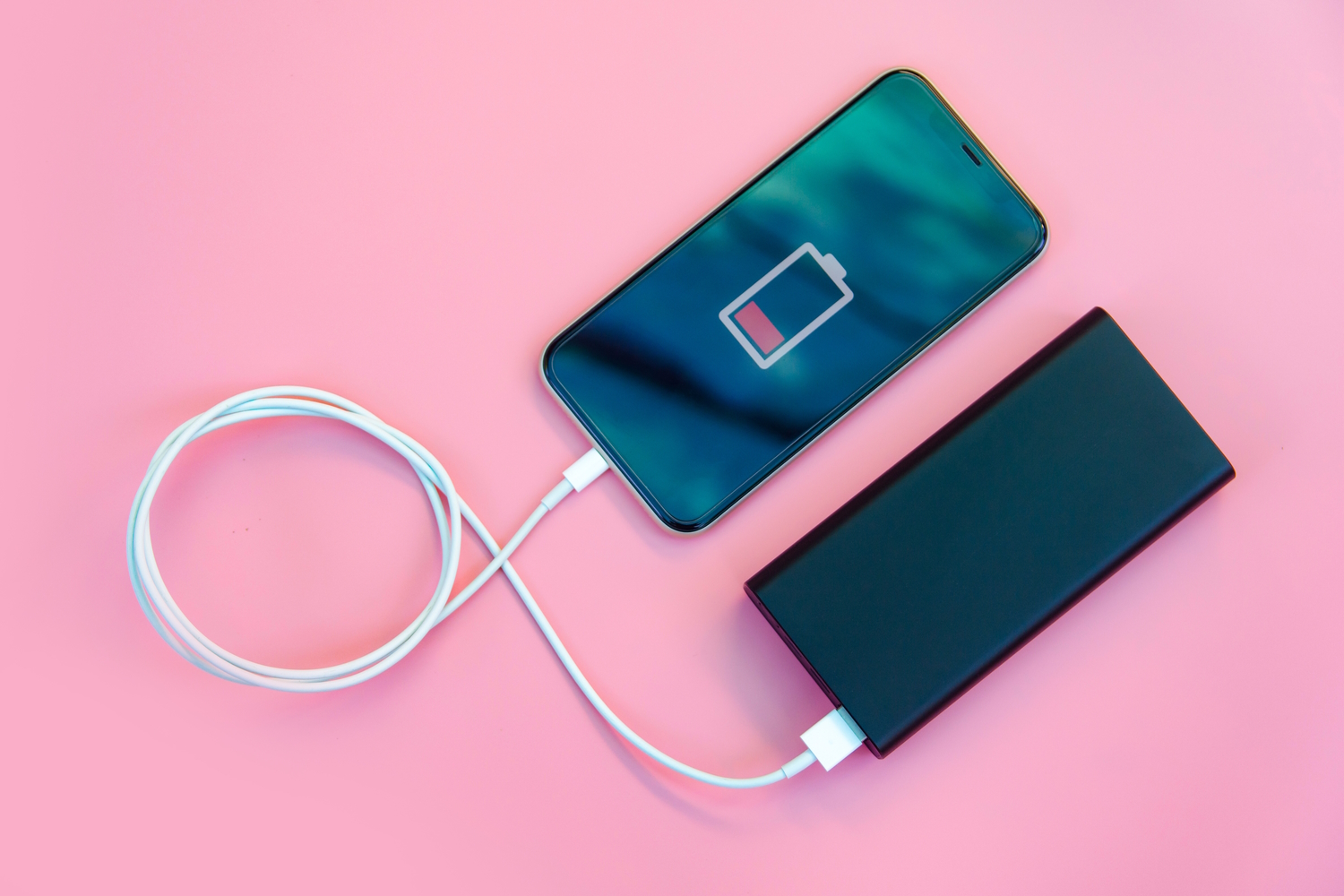 Plano cenital de una Powerbank carga un teléfono móvil sin batería 